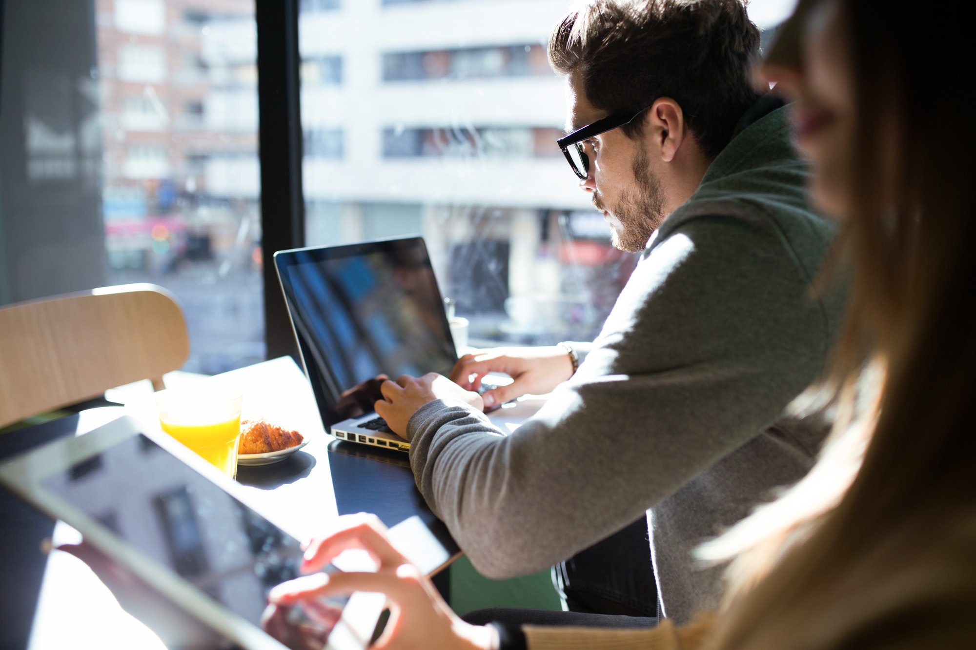 Beautiful young couple working with laptop in the coffee.