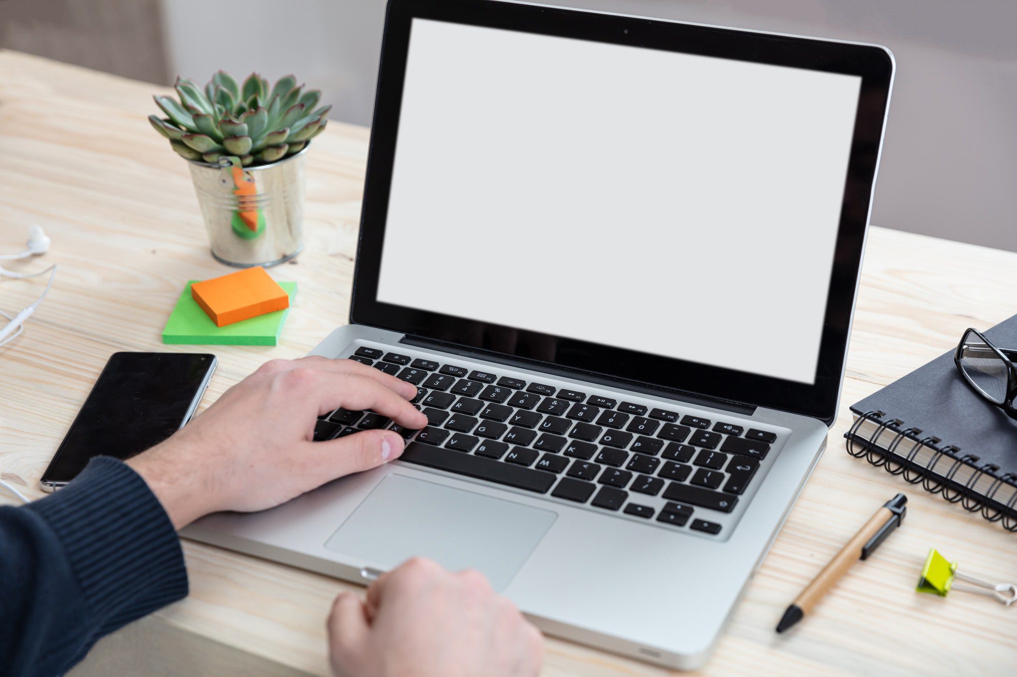 Laptop with white blank screen on a wooden desk