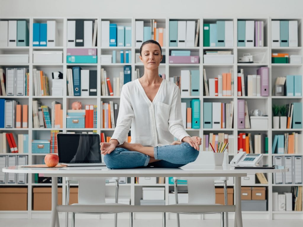 Woman practicing meditation on a desk