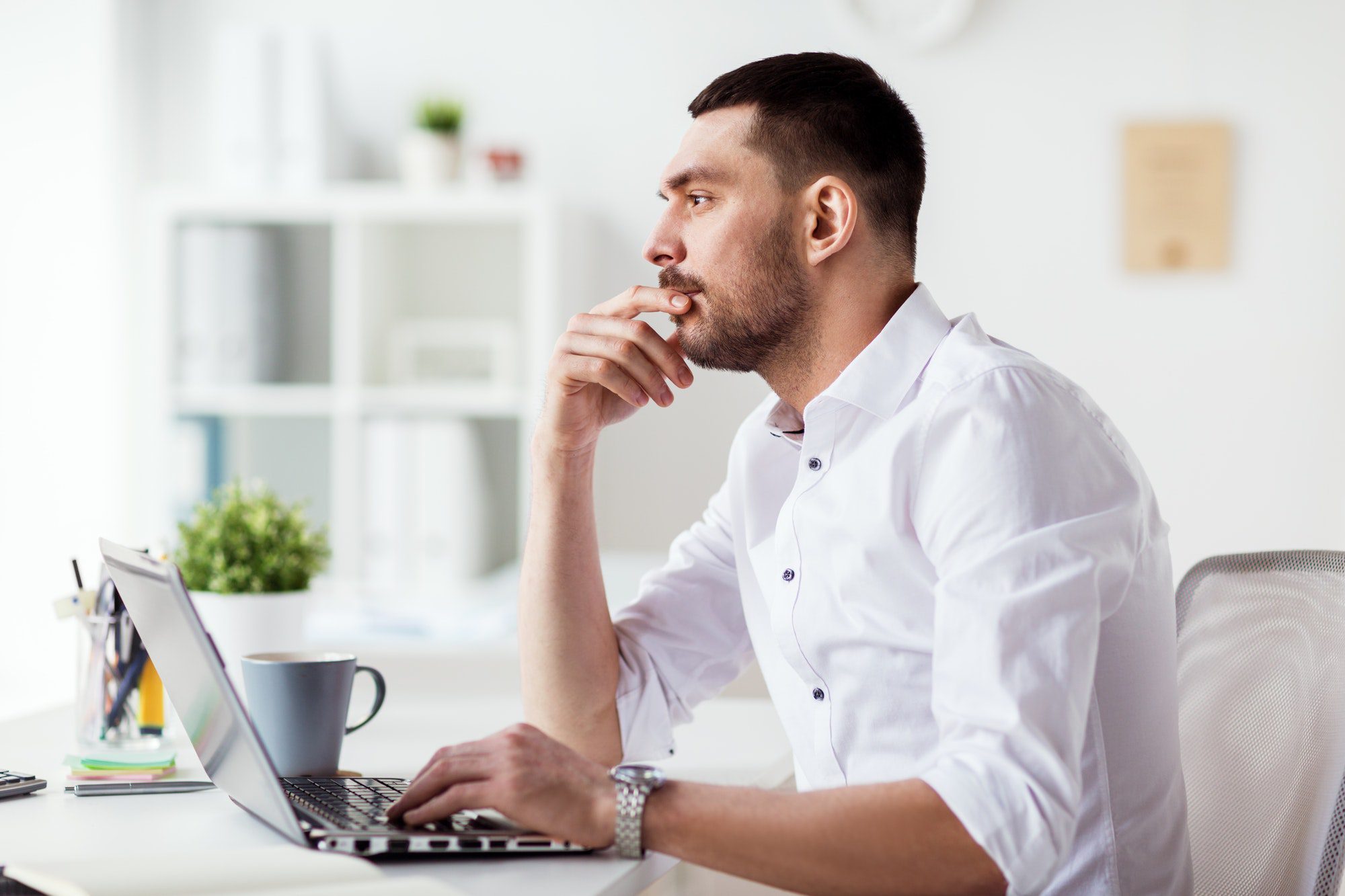 businessman with laptop thinking at office