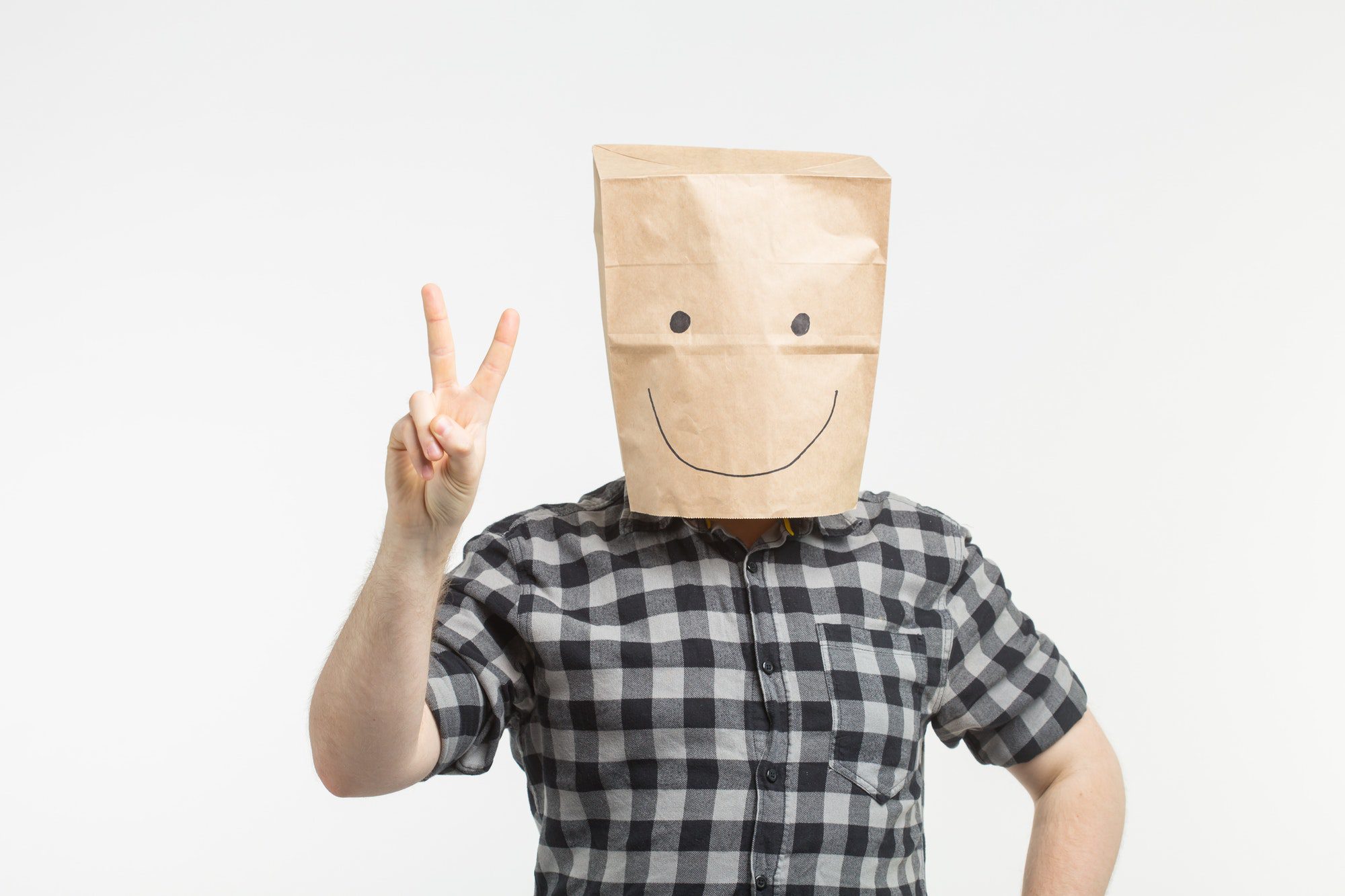 men in paper bag mask showing peace